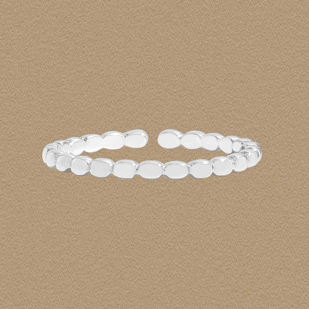 Polished sterling silver ring with a row of rounded oval beads on a beige background.