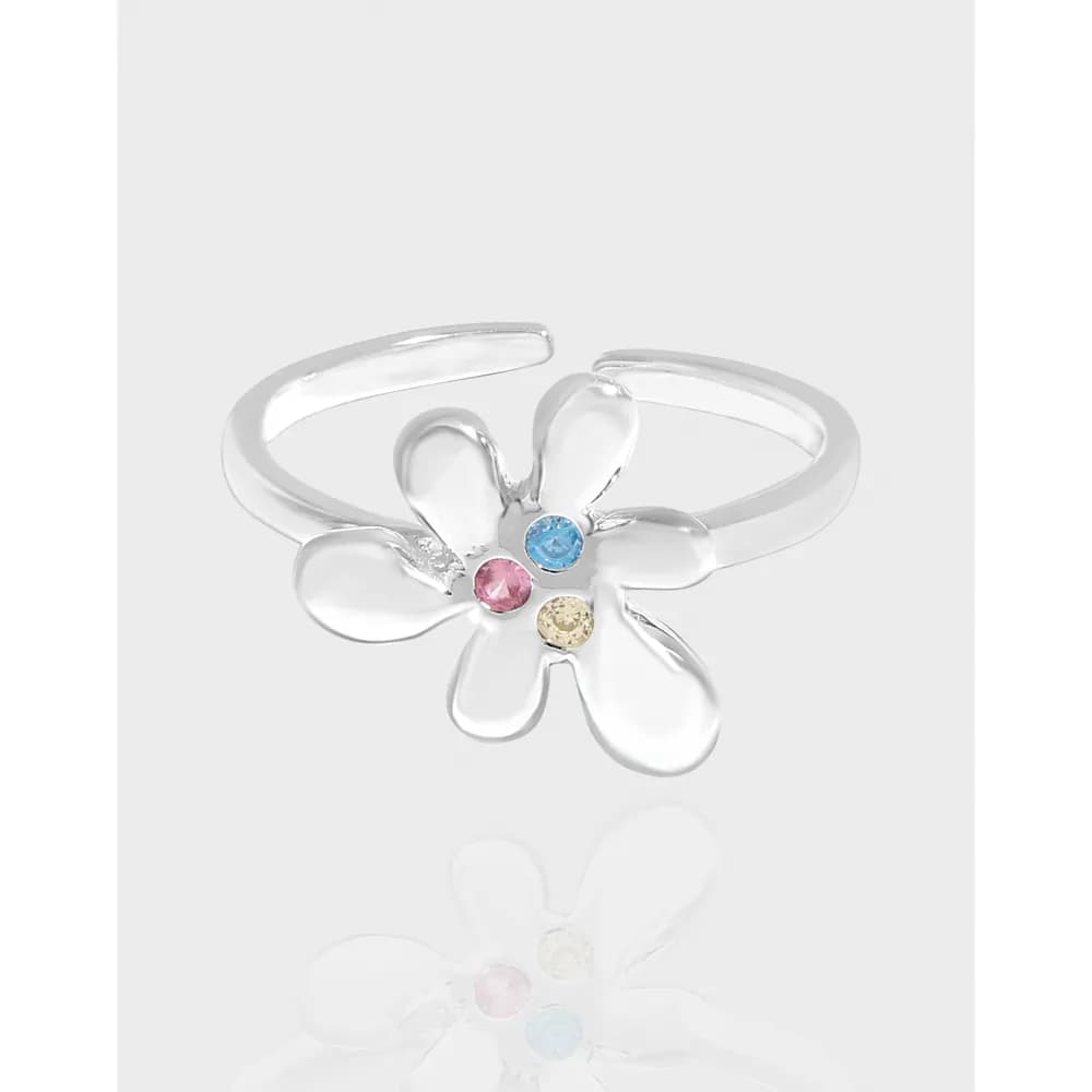 Polished sterling silver ring with a five-petal flower and colorful center stones on an open band.