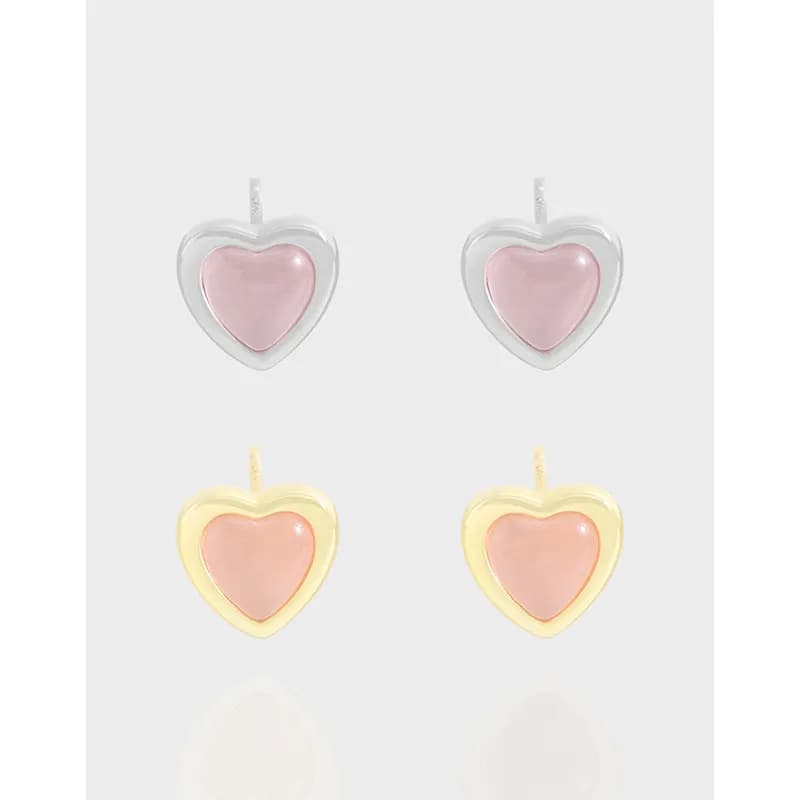 Polished silver heart stud earrings with pink enamel centers on a light background.