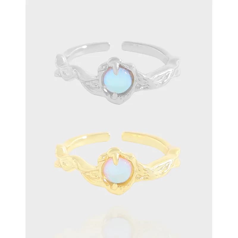 Front view of a vine motif opal ring in silver and gold tones with a round opalescent centerpiece.