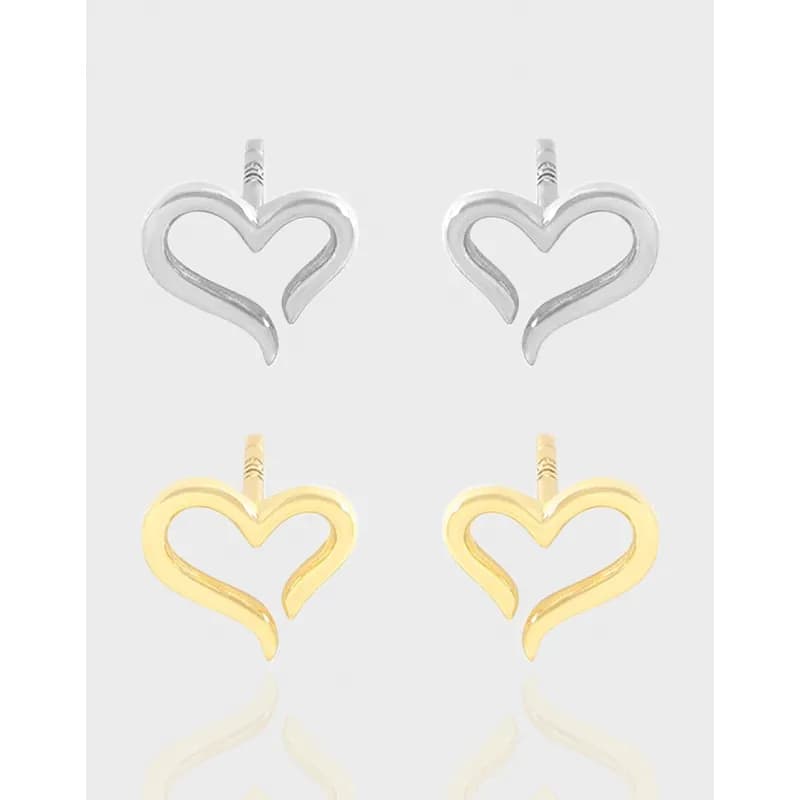 Two-tone heart-shaped open-loop earrings in polished silver and gold-tone finishes on a light background.