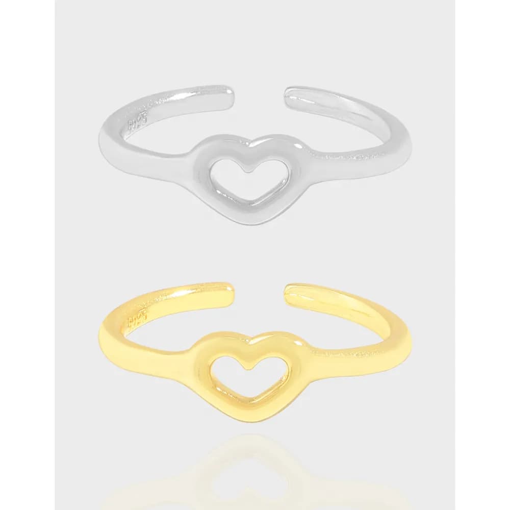 Polished open-heart ring in silver and gold tones with an open back and heart motif on a light gray backdrop.