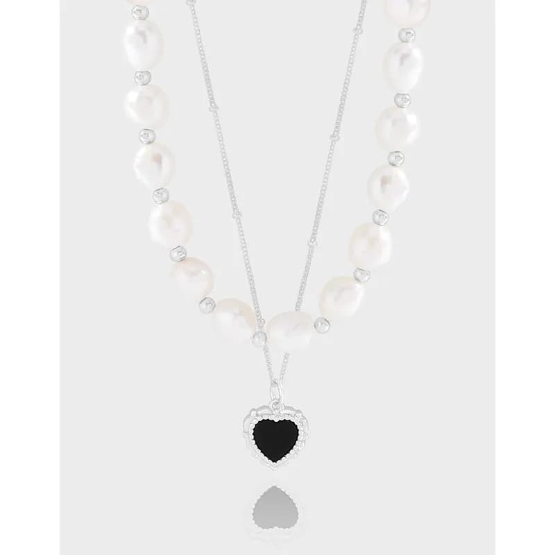 Two-layer sterling silver necklace featuring pearl beads and a heart pendant with a beaded silver border.