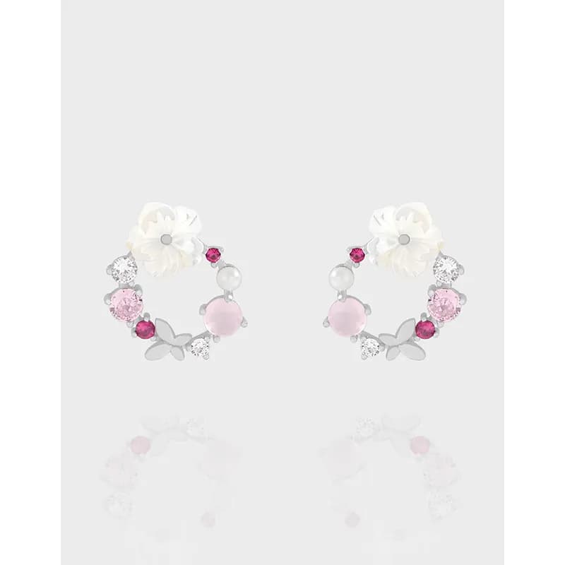 Polished sterling silver hoop earrings with a white flower accent and pink stones forming a floral motif.
