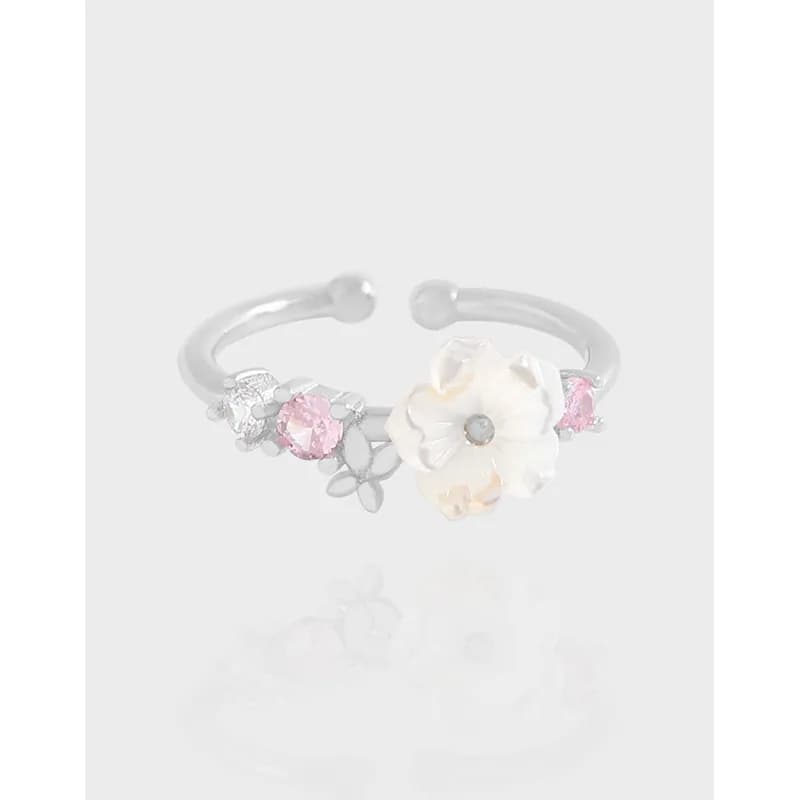 Open floral ring in polished silver with a large cream flower and pink stones