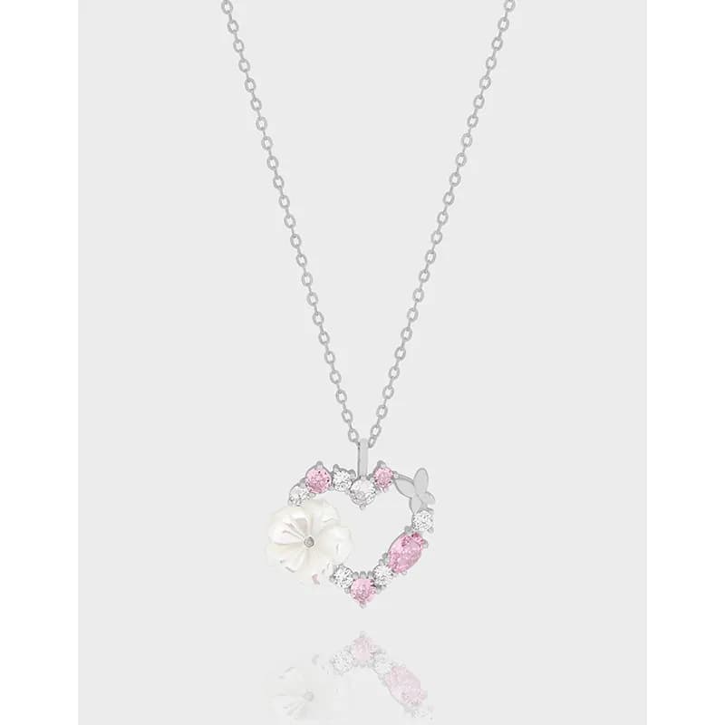Polished sterling silver necklace with a heart-shaped pendant featuring a white flower and pink stone accents.