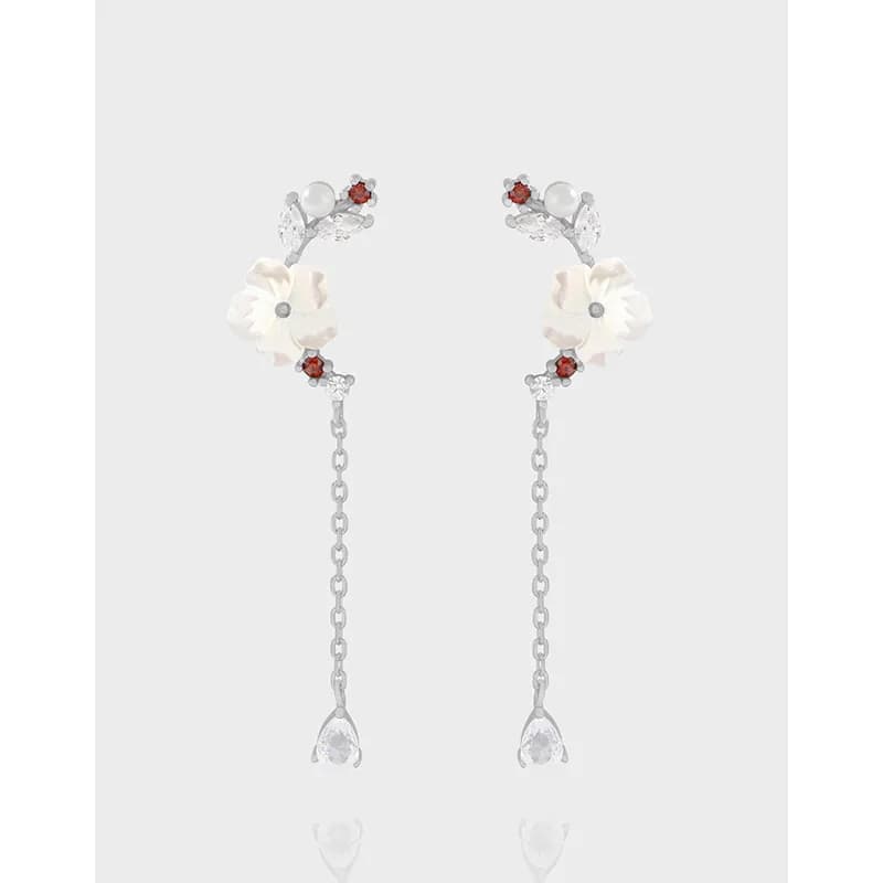 Pair of polished sterling silver earrings with ivory flower petals and delicate chain drops ending in clear teardrop crystals.