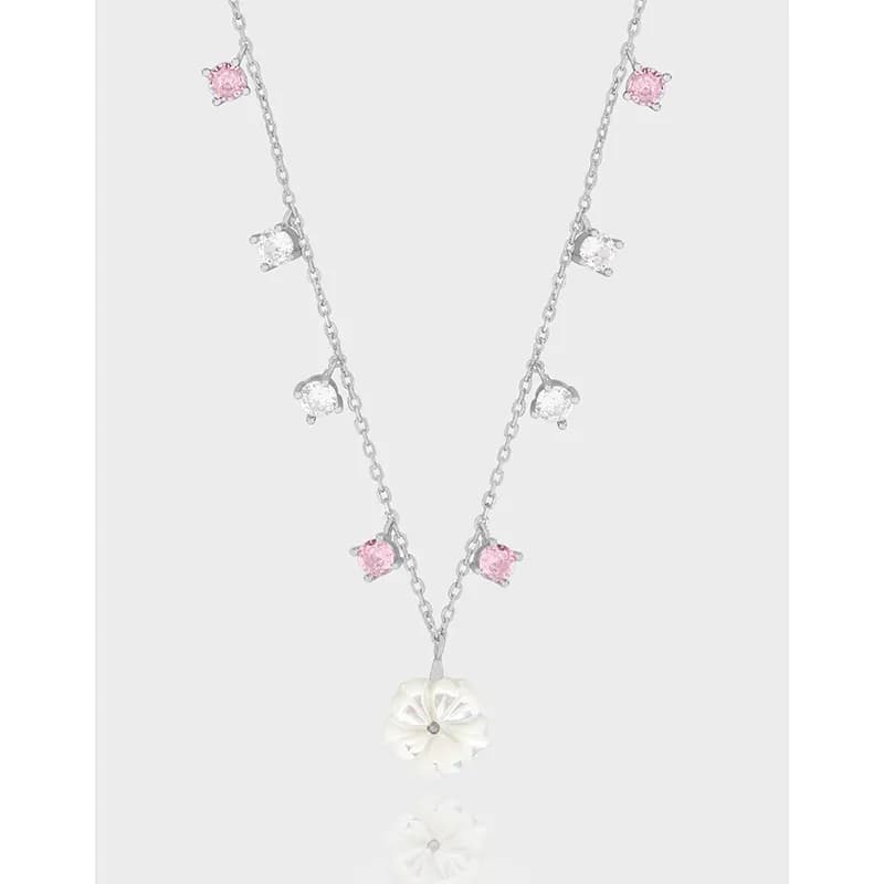 Polished sterling silver necklace with pink and clear stones and a white carved flower pendant