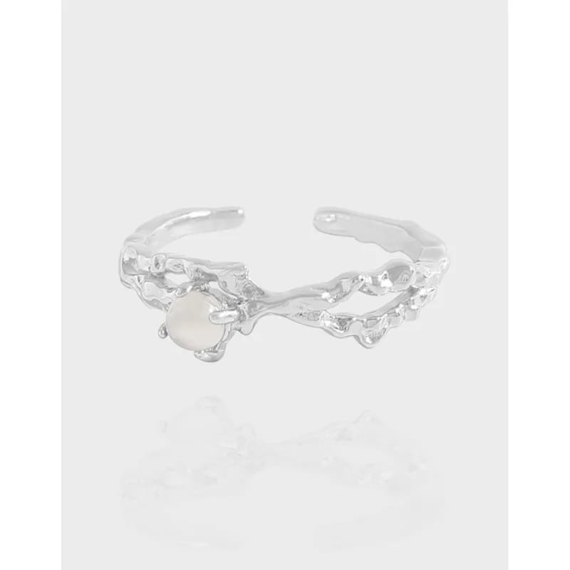 Polished sterling silver adjustable ring with a textured, organic band and a small pearl accent on the side.