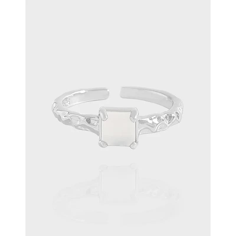Sterling silver ring with square bezel setting and leafy textured band.