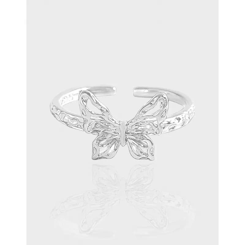 Polished sterling silver butterfly ring with openwork wings on a light background.
