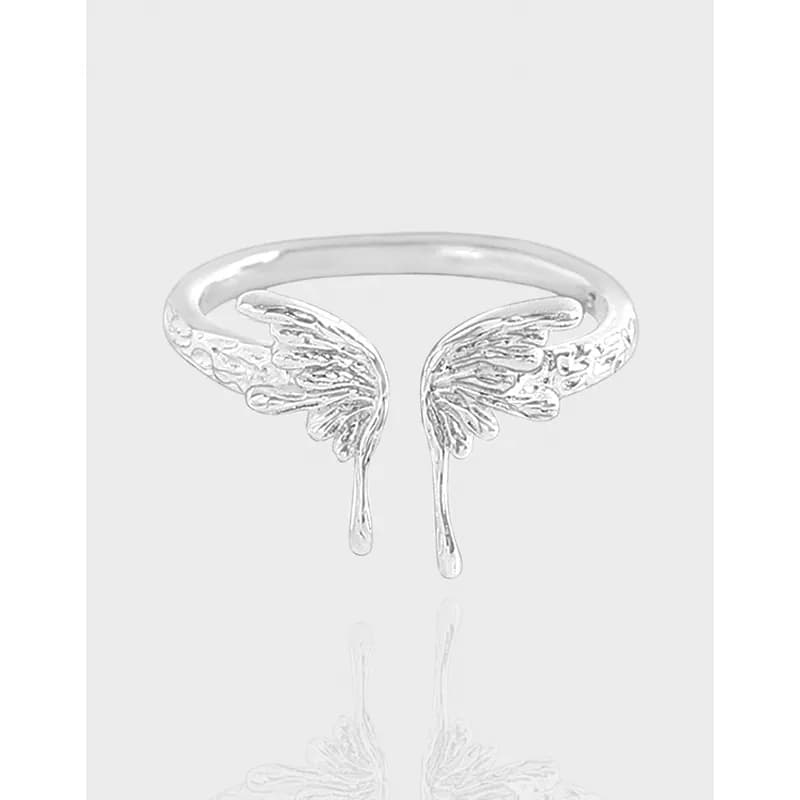 Polished sterling silver ring with twin wing motifs forming an open-front design.