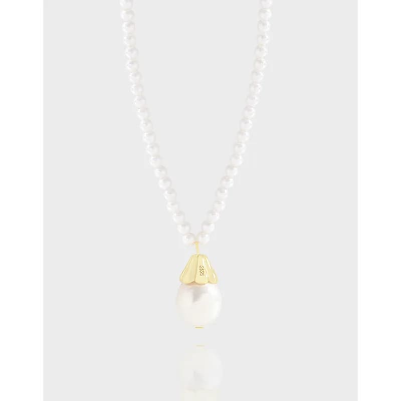 Pearl bead necklace with a gold cap on a white pearl pendant