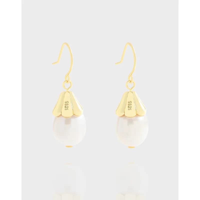 Polished sterling silver earrings with a pearl drop and gold-toned petal cap hanging from a slender hook.
