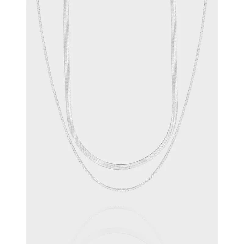 Triple-layered sterling silver chain necklace with polished finish on a light background.