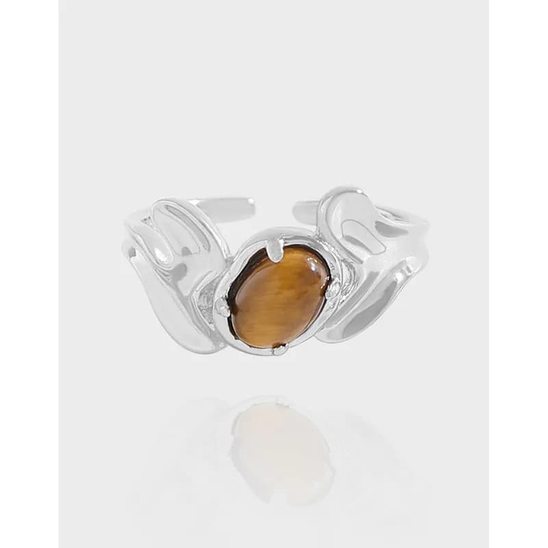 Polished sterling silver ring with an oval tiger's eye cabochon set in a sculptural flowing band.