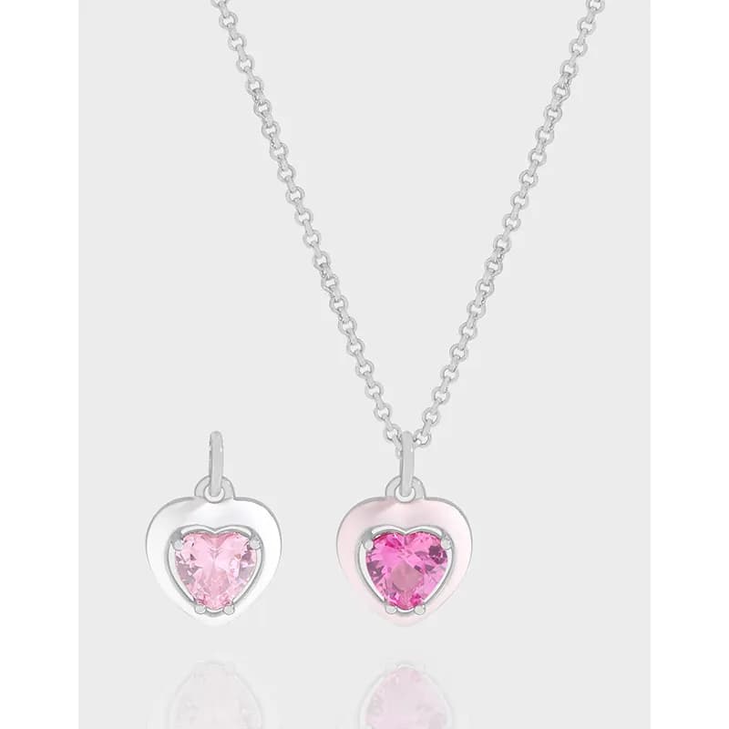 Two heart-shaped pendant necklaces with pink gemstones on a sterling silver chain