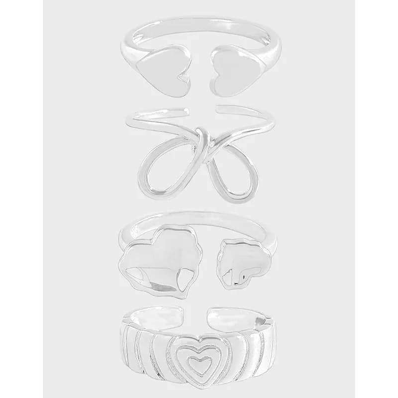 Vertical stack of five polished sterling silver rings with hearts, infinity symbol, and floral cutouts