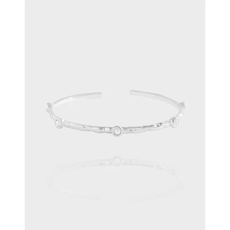 Open sterling silver cuff bracelet with a textured band and small bead accents along its length.