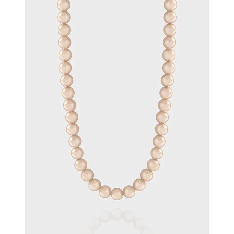 Polished sterling-silver chain holds a strand of uniform champagne pearls, showcased in a clean, minimal necklace.