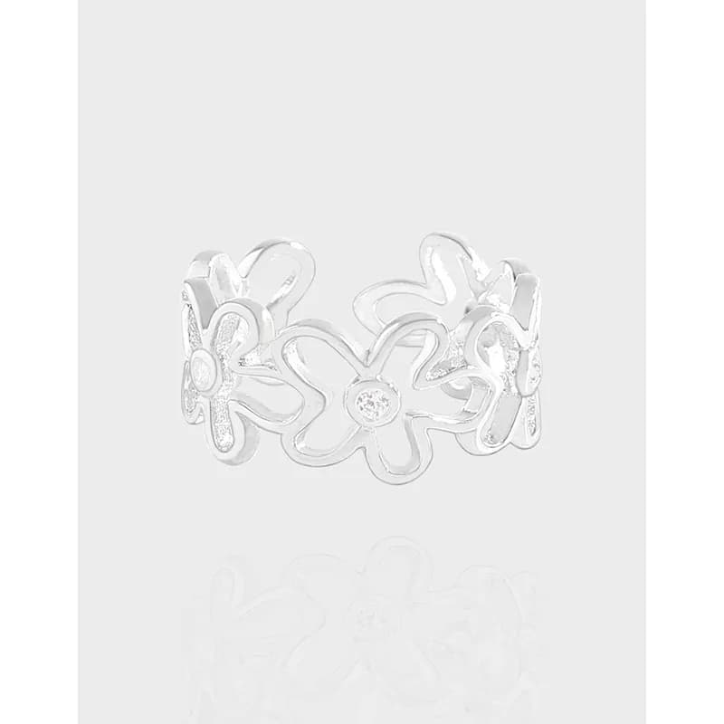 Polished sterling silver ring with connected flower shapes forming an openwork band.