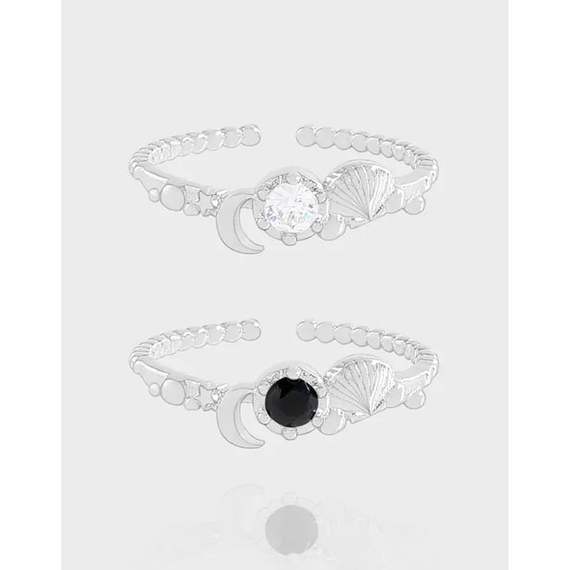 Polished silver open-ring with moon, shell, star charms and a central crystal on the finger