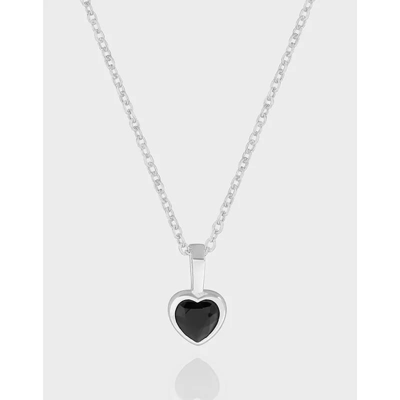 Polished sterling silver chain with a heart-shaped pendant containing a black gemstone