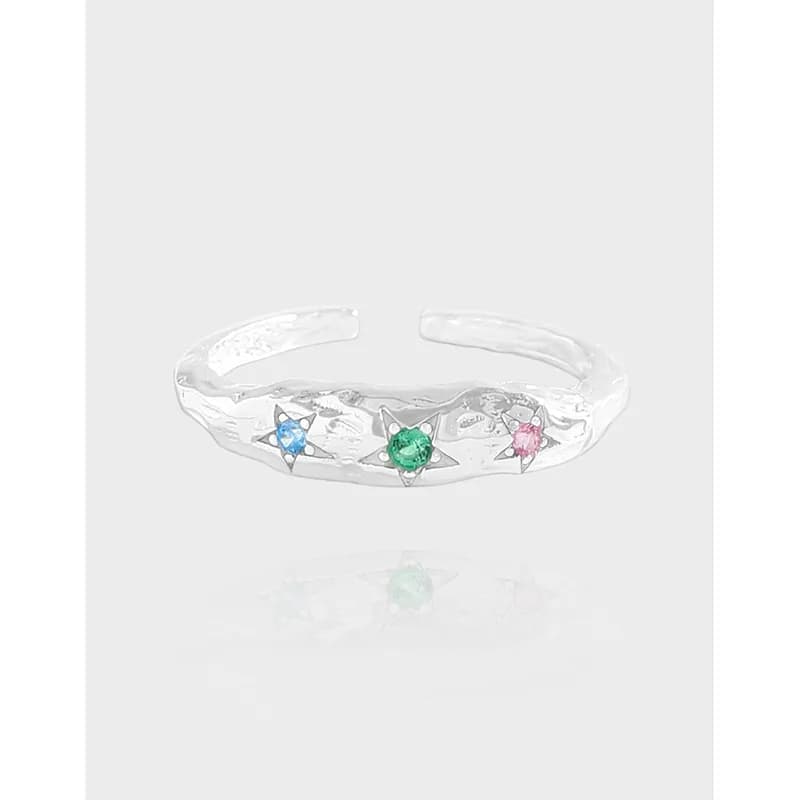 Hammered sterling silver ring with three star-set stones in blue, green, and pink on an open-band design.