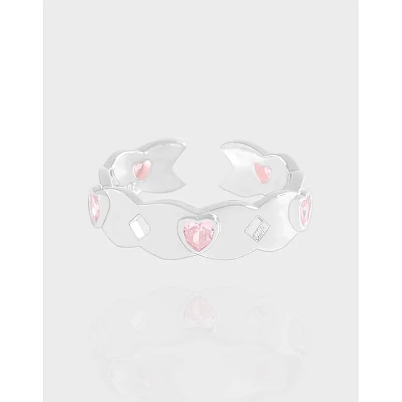 Polished sterling silver ring with pink heart stones arranged along a curved open band.