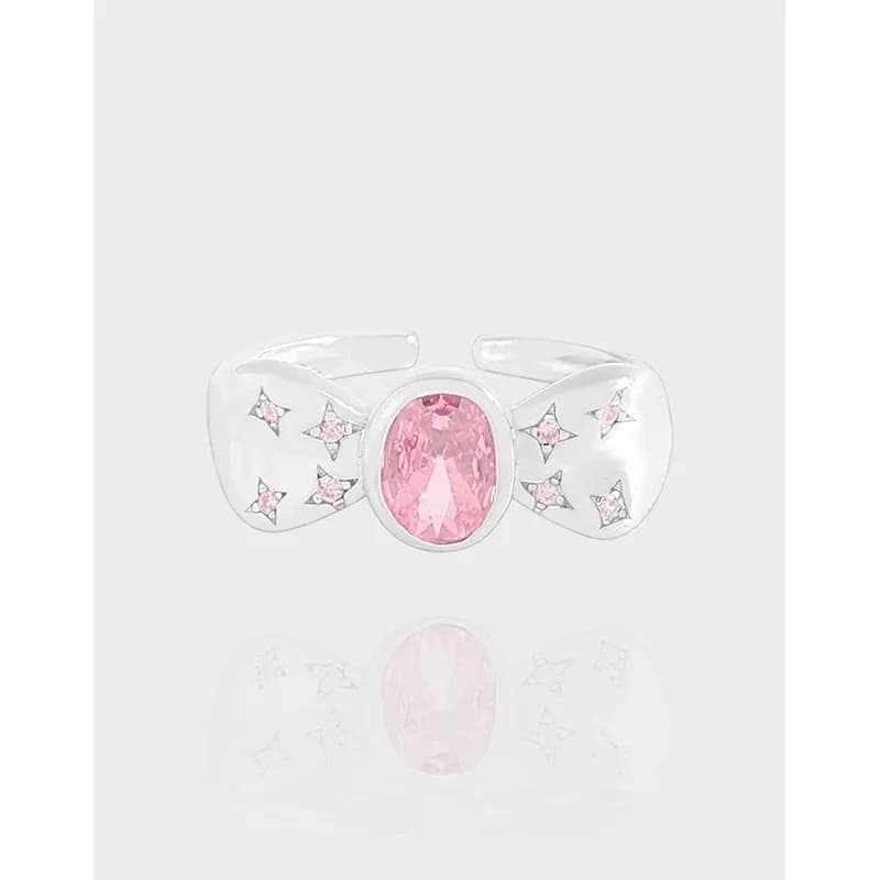 Polished sterling silver bow-shaped ring with a central pink oval gemstone and small pink stones on the bow wings