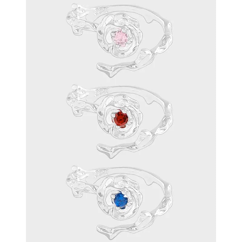 Polished sterling silver ring with a floral rosette centerpiece and a colored gemstone in the middle, shown in three color options.