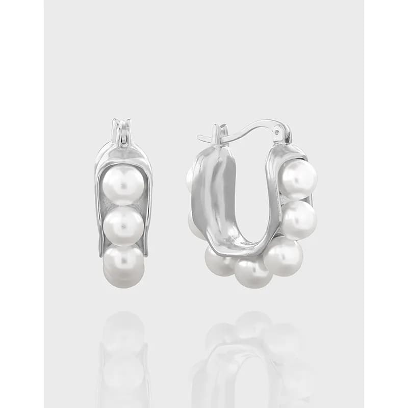 Polished silver hoop earrings with three evenly spaced pearls along the outer edge.