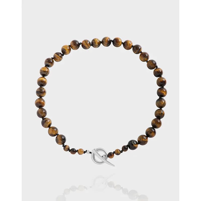 Polished tiger eye bead necklace with silver toggle clasp shown against a light backdrop.