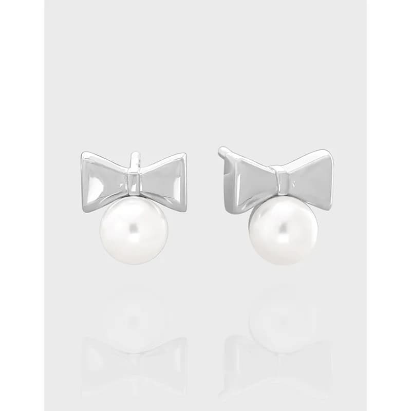 Polished sterling silver bow earrings with hanging faux-pearl drops.