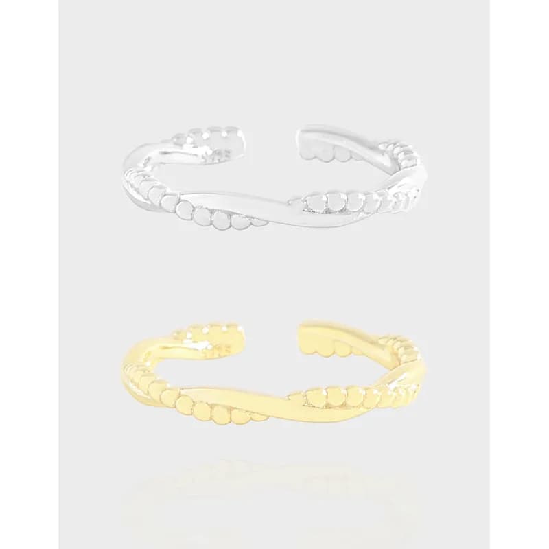 Open-ended ring with a curved central band and beaded edges in silver and gold-tone finishes.