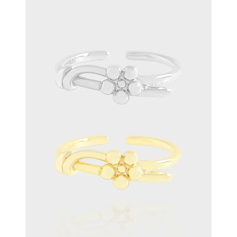 Polished two-tone five-petal flower ring with a double-band open cuff on a light background.
