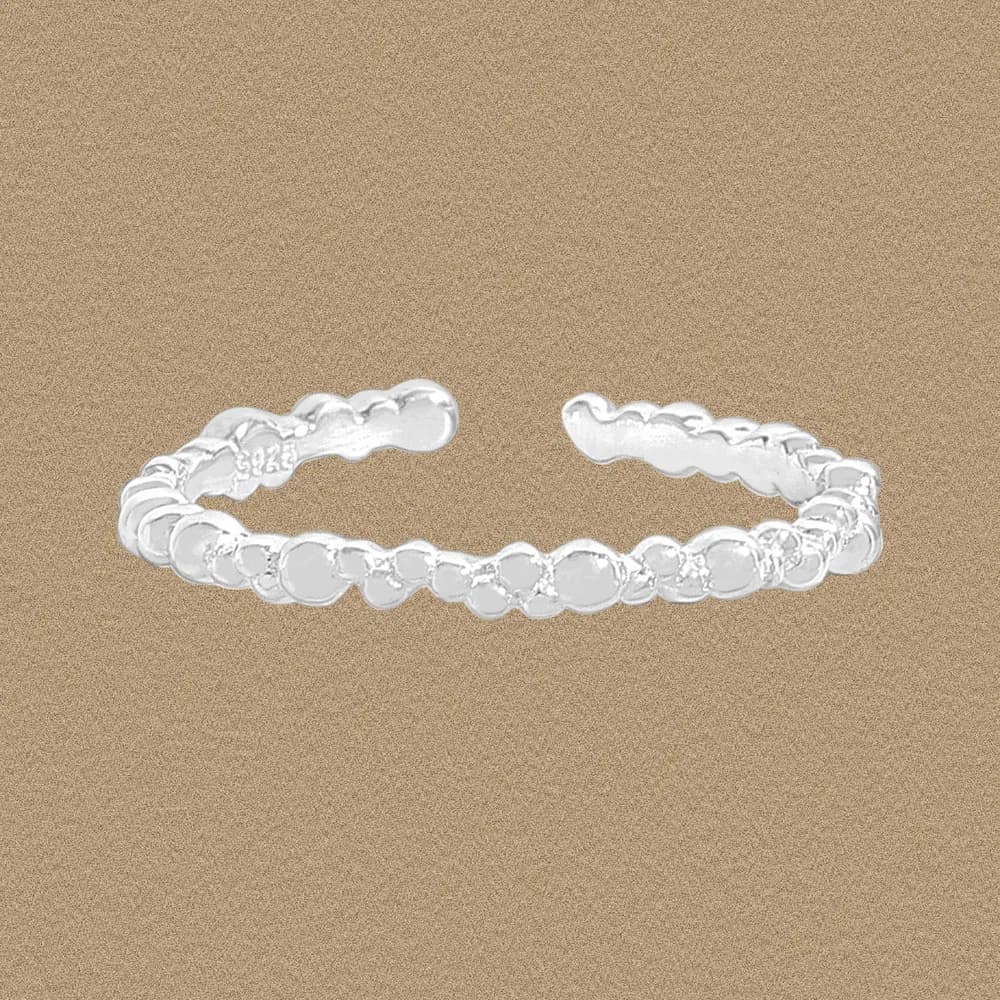 Polished sterling silver beaded disc ring in an open cuff shape on a neutral background.