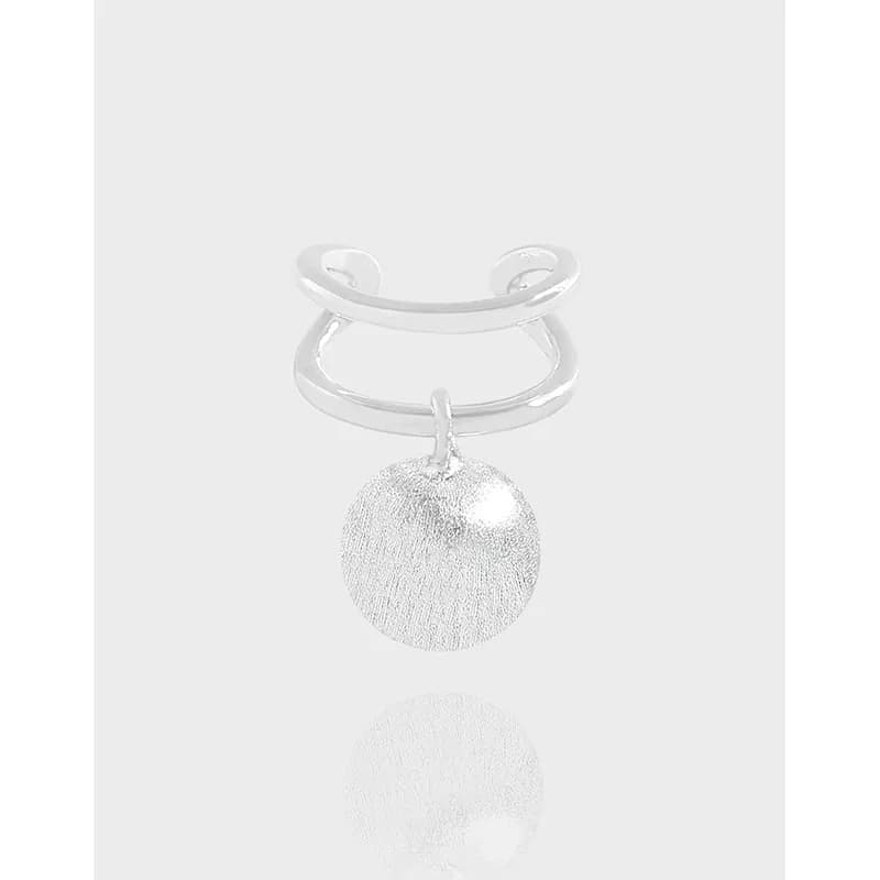 Polished sterling silver double hoop earrings with a textured circular disc charm hanging from the bottom