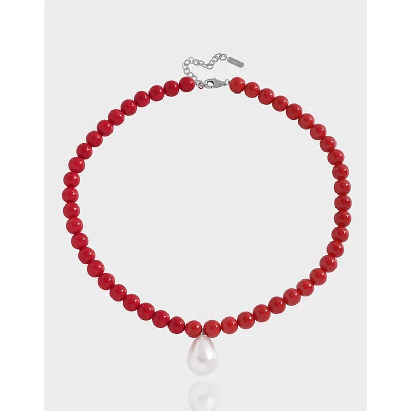 Polished sterling silver necklace with red beads and a white teardrop pearl pendant