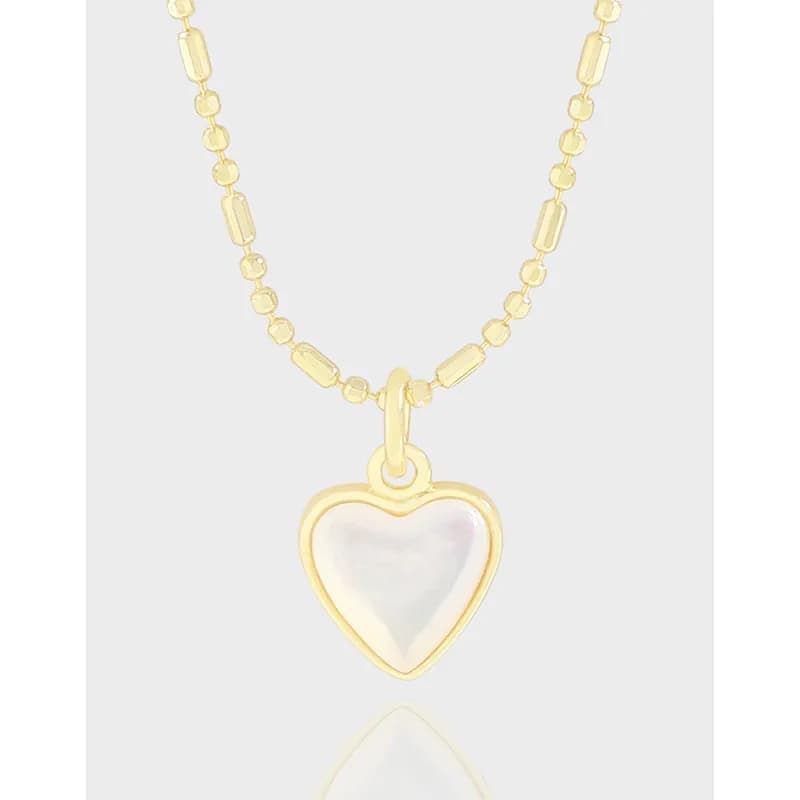 Gold-tone heart pendant necklace with mother-of-pearl center on a beaded and rectangular-link chain.