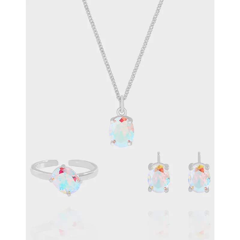 Polished sterling silver oval opal studs with a matching pendant and ring on a light background.