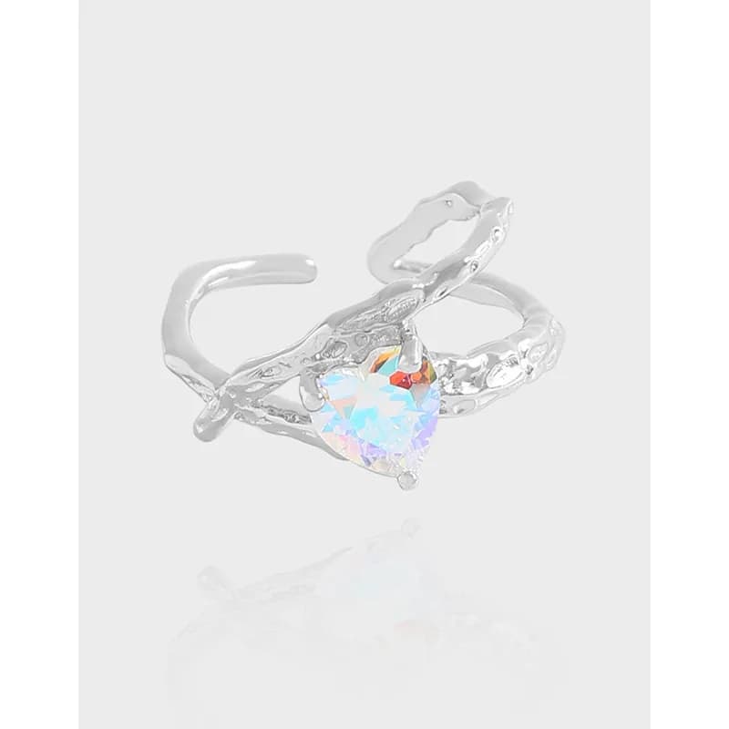 Polished sterling silver ring with a heart-shaped iridescent gemstone set in a prong setting on a textured band.