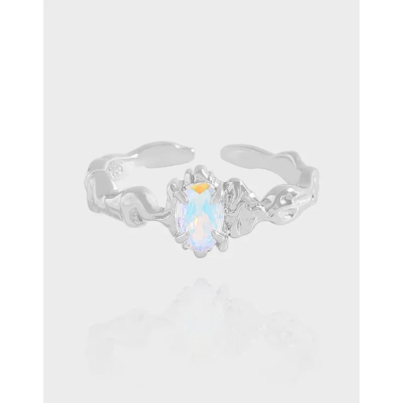 Polished sterling silver ring with an oval opal-like center stone set in prongs on a wavy band.
