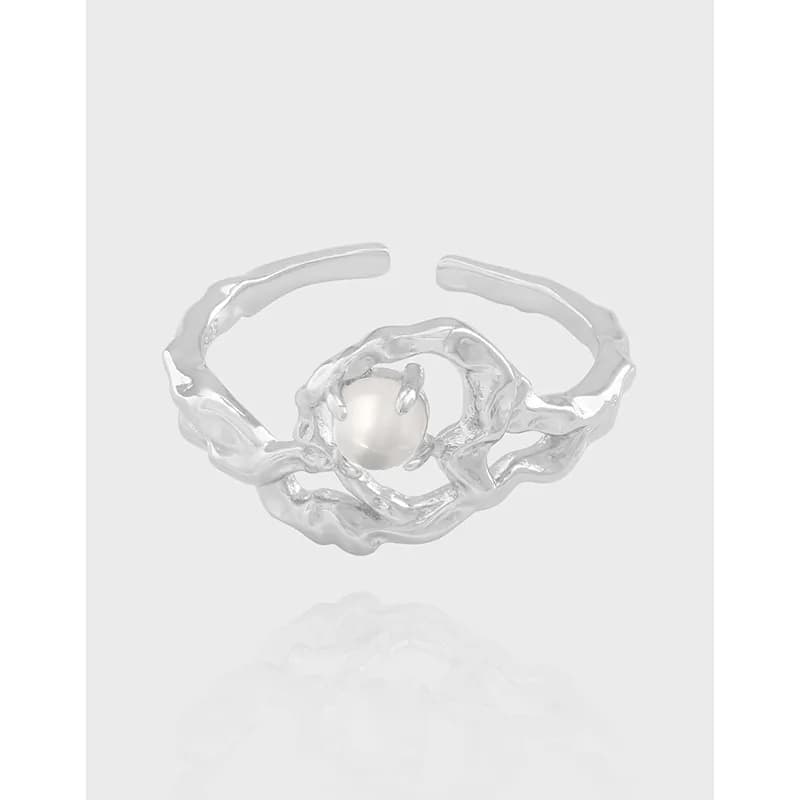 Polished sterling silver ring with an irregular twisted band and a central pearl.