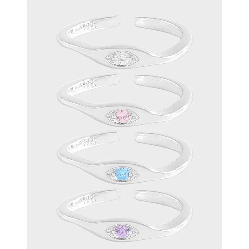 Polished sterling silver eye-m motif ring with a colored center stone on an open band