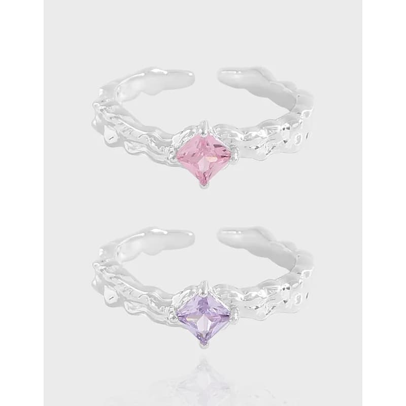 Two polished sterling silver rings with textured organic bands and square-cut pink gemstones in prong settings