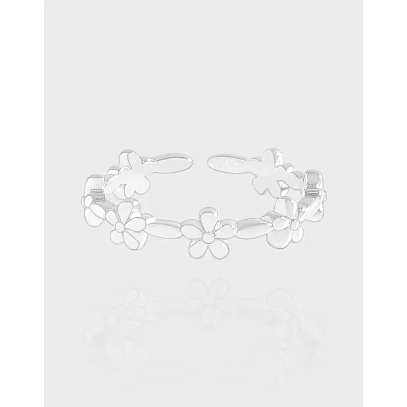 Open sterling silver ring with connected five-petal flowers forming a delicate floral band.