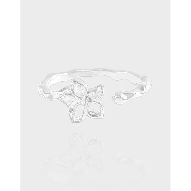 Polished sterling silver flower ring with a five-petal blossom on a wavy open-band design.