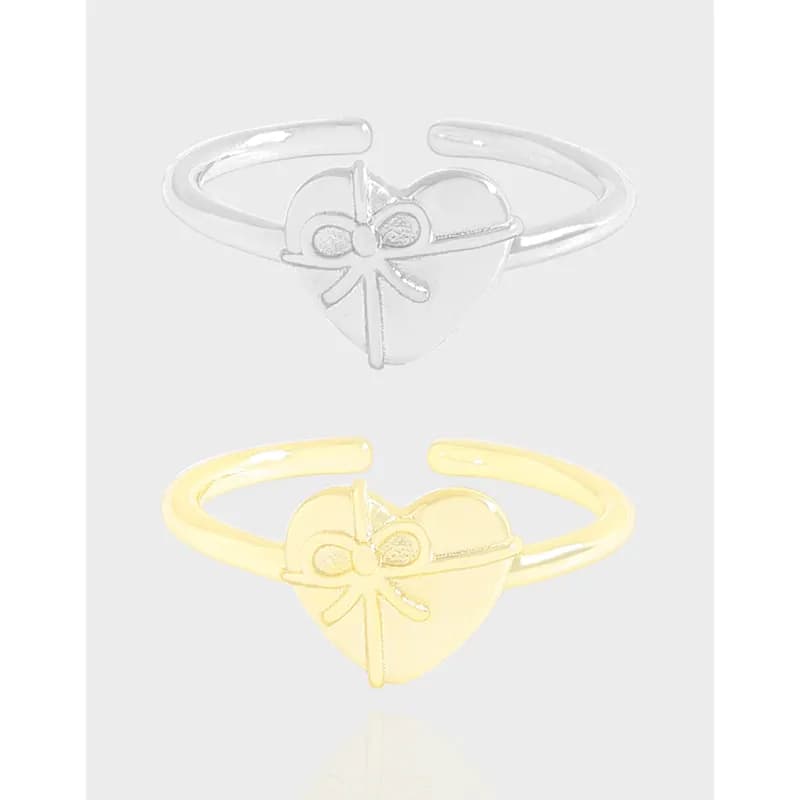 Polished sterling silver ring with a heart shape and bow motif on the front