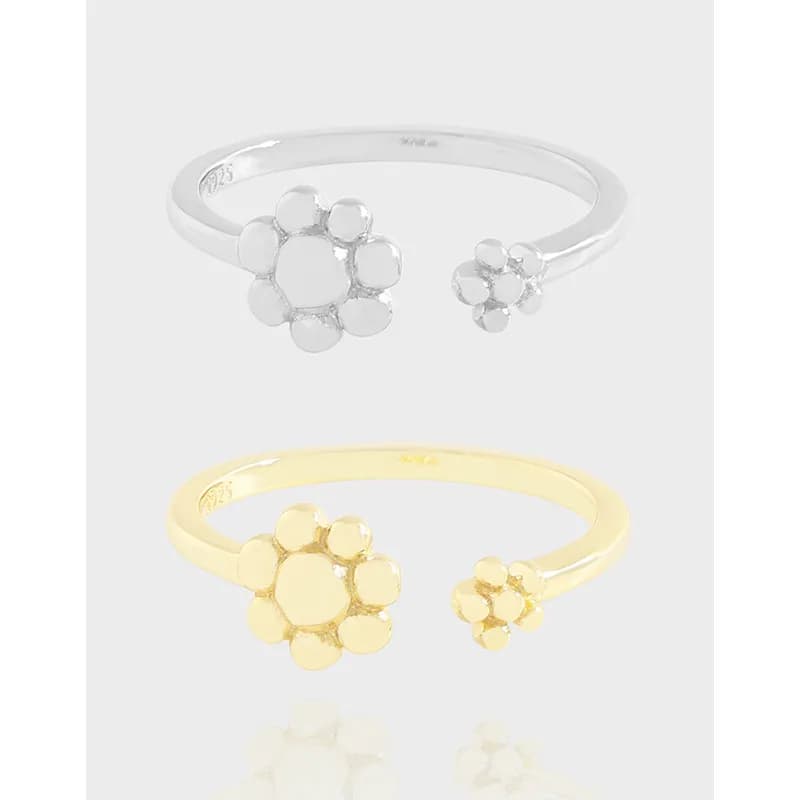 Open-ended ring with two flower-cluster ends in silver and gold tones.